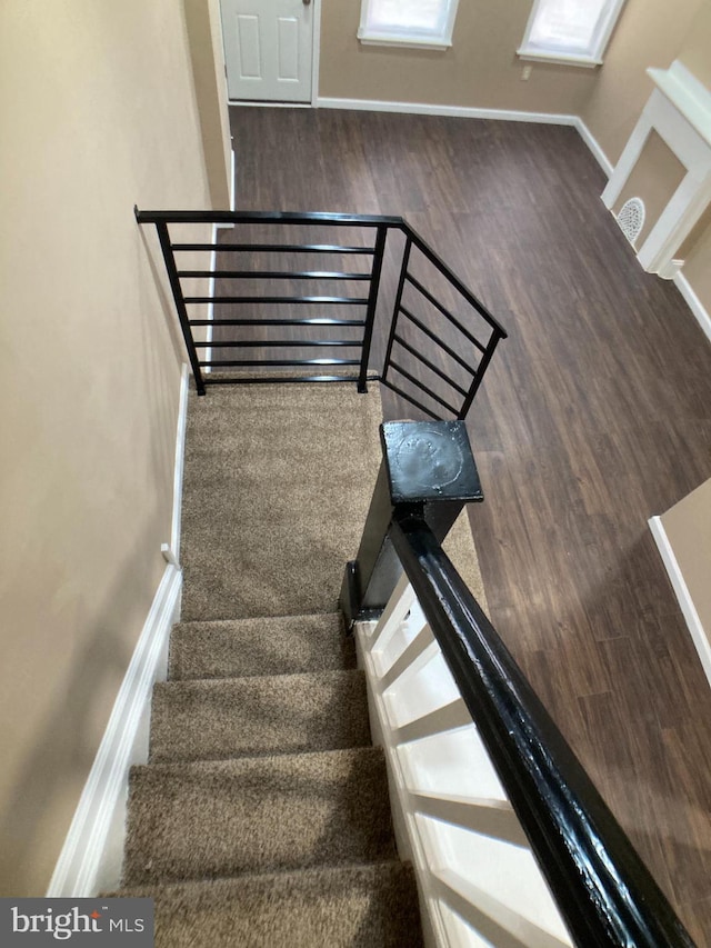 stairway featuring baseboards and wood finished floors