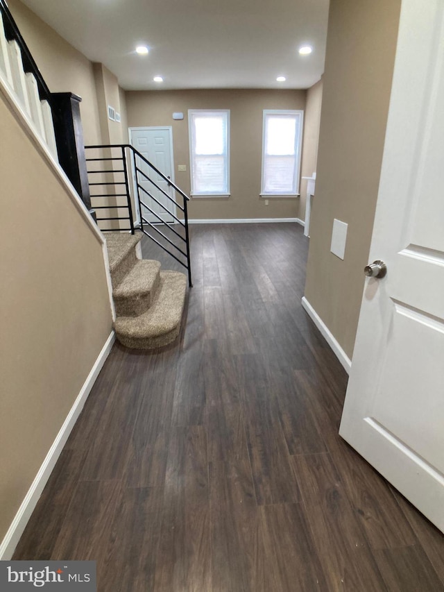 interior space featuring dark wood-style floors, stairway, baseboards, and recessed lighting