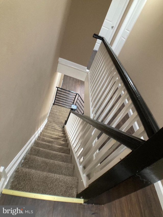 staircase with carpet floors and baseboards