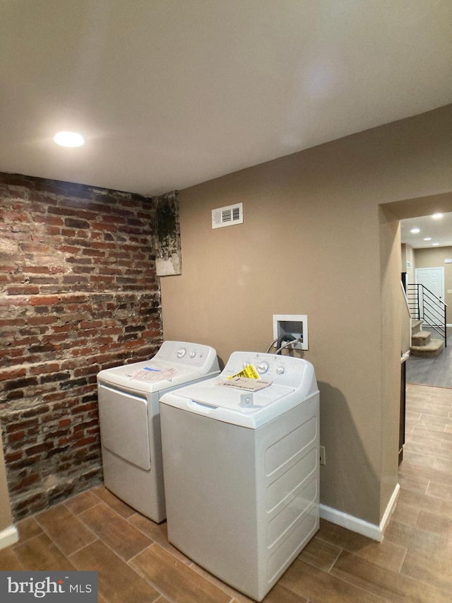 laundry room with visible vents, wood tiled floor, laundry area, independent washer and dryer, and baseboards