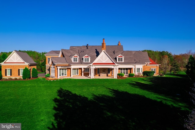 22577 Creighton Farms Dr, Leesburg, VA 20175 - back of house featuring a patio area, a yard, and a chimney
