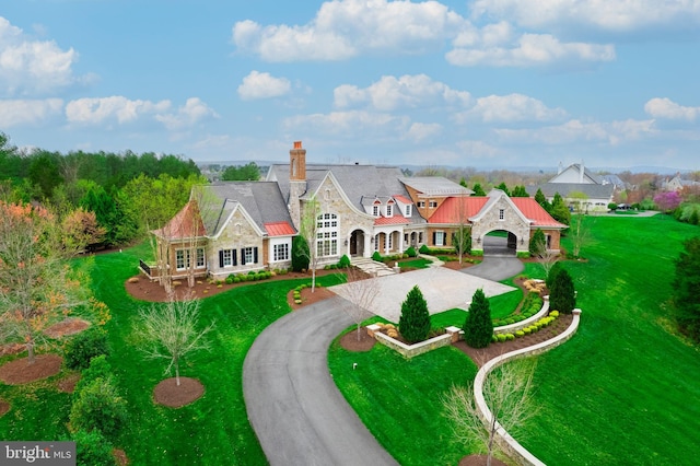 22577 Creighton Farms Dr, Leesburg, VA 20175 - view of front facade with curved driveway, a front yard, stone siding, and a chimney