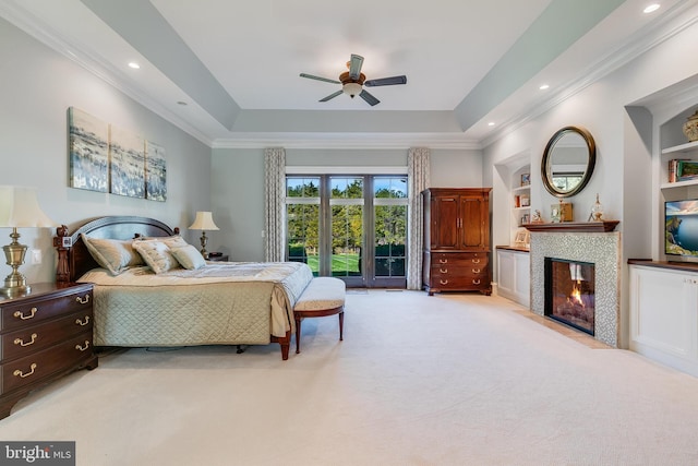 22577 Creighton Farms Dr, Leesburg, VA 20175 - bedroom with crown molding, a tray ceiling, light colored carpet, a ceiling fan, and a tiled fireplace