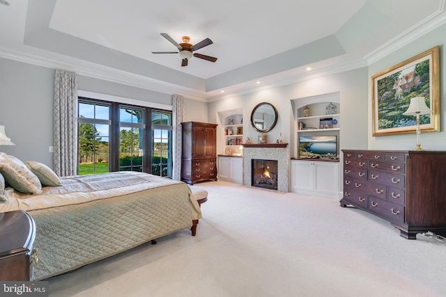 22577 Creighton Farms Dr, Leesburg, VA 20175 - bedroom with crown molding, a tray ceiling, a tiled fireplace, and light carpet