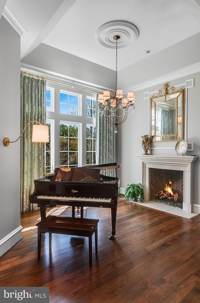 22577 Creighton Farms Dr, Leesburg, VA 20175 - living area featuring baseboards, a warm lit fireplace, a chandelier, crown molding, and wood finished floors
