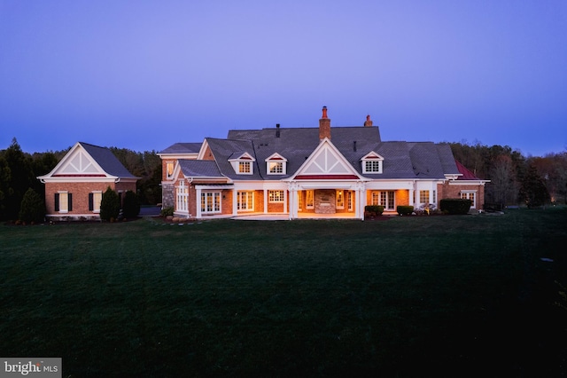 22577 Creighton Farms Dr, Leesburg, VA 20175 - back of property at dusk featuring french doors, a patio, a yard, and a chimney