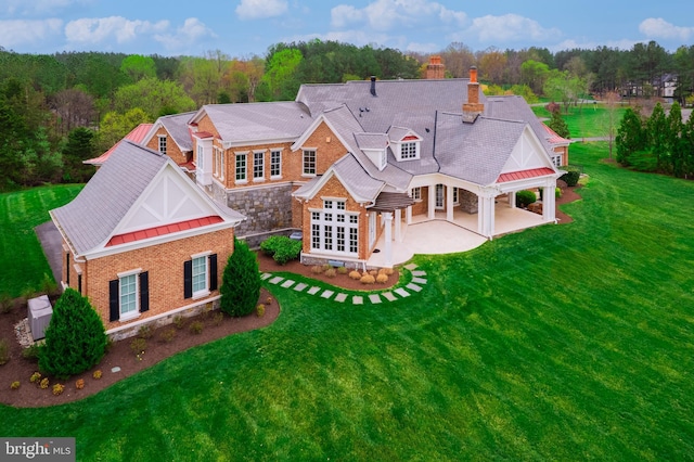 22577 Creighton Farms Dr, Leesburg, VA 20175 - back of property featuring a patio area, stone siding, a lawn, a chimney, and driveway