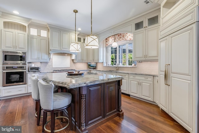 22577 Creighton Farms Dr, Leesburg, VA 20175 - kitchen featuring built in appliances, dark wood-style flooring, decorative backsplash, and a kitchen island