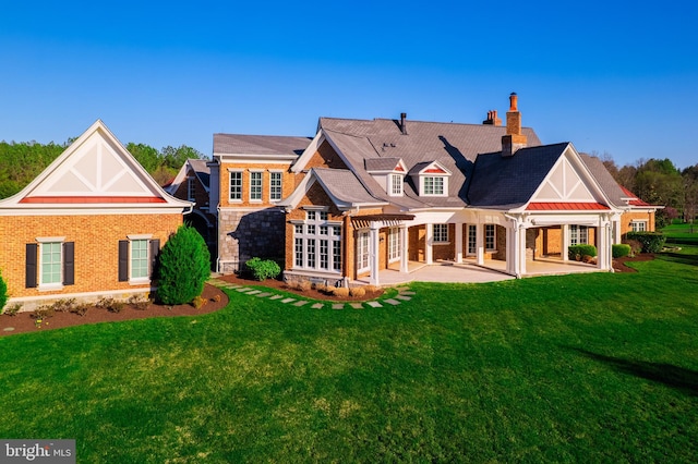 22577 Creighton Farms Dr, Leesburg, VA 20175 - back of house with a patio, a chimney, brick siding, and a lawn