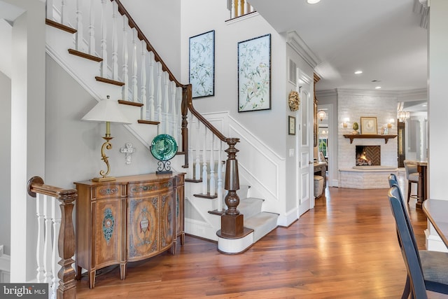 22577 Creighton Farms Dr, Leesburg, VA 20175 - stairs with wood finished floors, ornamental molding, a large fireplace, and recessed lighting