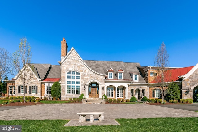 22577 Creighton Farms Dr, Leesburg, VA 20175 - view of front of property featuring a chimney, metal roof, and stone siding
