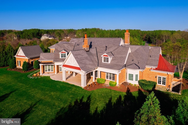 22577 Creighton Farms Dr, Leesburg, VA 20175 - back of house featuring a patio, brick siding, a forest view, and a lawn
