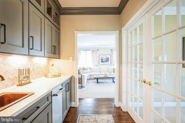 kitchen with light countertops, gray cabinets, a sink, and crown molding