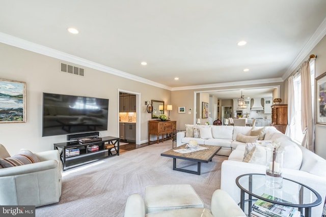 living area featuring ornamental molding, recessed lighting, and visible vents