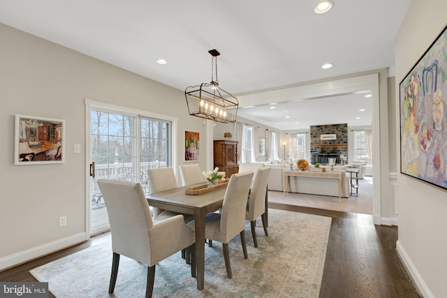 dining space featuring recessed lighting, a brick fireplace, baseboards, and wood finished floors