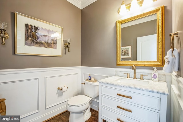 bathroom featuring a wainscoted wall, toilet, wood finished floors, and vanity