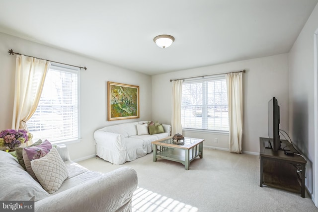 living area featuring baseboards and light colored carpet