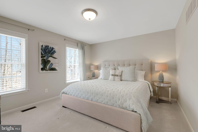 carpeted bedroom with visible vents, baseboards, and multiple windows