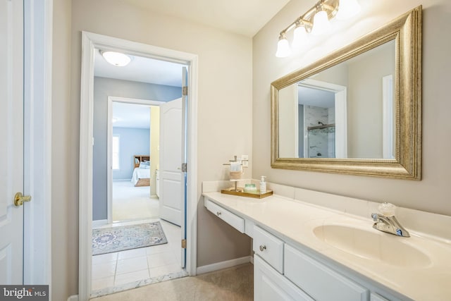 bathroom featuring baseboards, ensuite bathroom, tile patterned flooring, walk in shower, and vanity