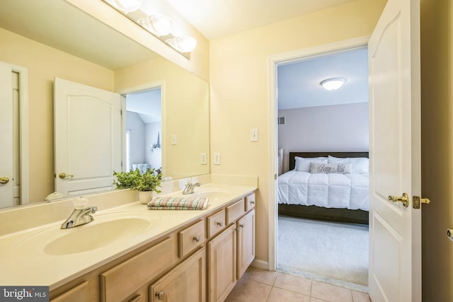 ensuite bathroom featuring double vanity, tile patterned floors, a sink, and ensuite bathroom