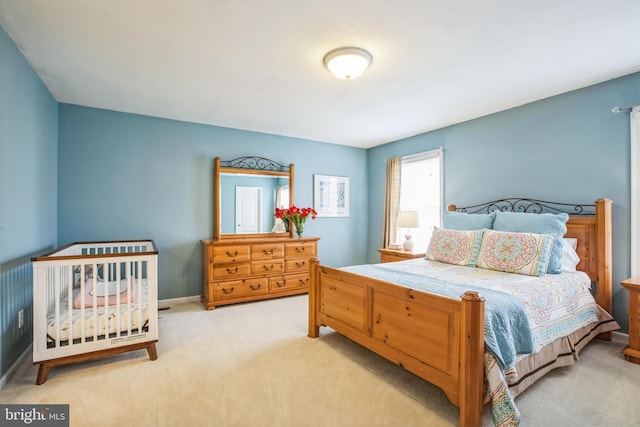 bedroom with light colored carpet and baseboards