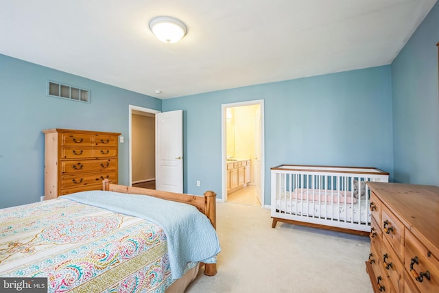 bedroom featuring light carpet, connected bathroom, visible vents, and baseboards