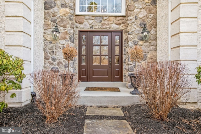 doorway to property with stone siding