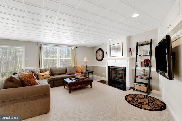 living area with a fireplace with flush hearth, carpet floors, and baseboards