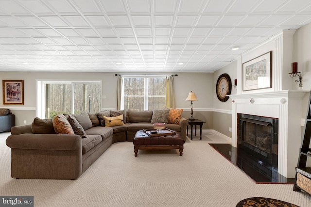 living room with carpet floors, recessed lighting, a fireplace with flush hearth, and baseboards