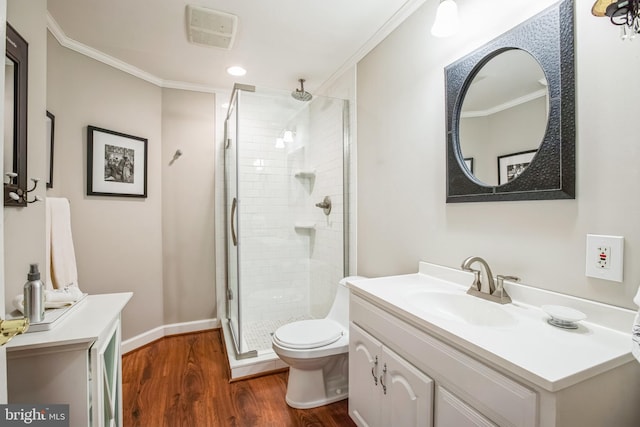 bathroom with toilet, ornamental molding, vanity, a shower stall, and wood finished floors