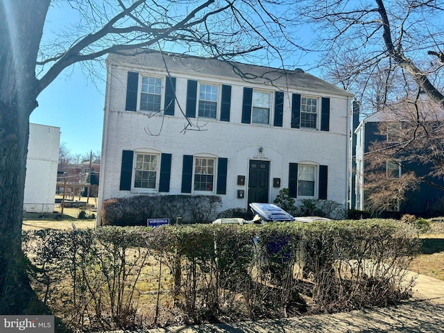 colonial-style house with brick siding and fence