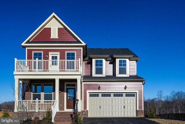 view of front of home featuring aphalt driveway, an attached garage, a balcony, covered porch, and a shingled roof