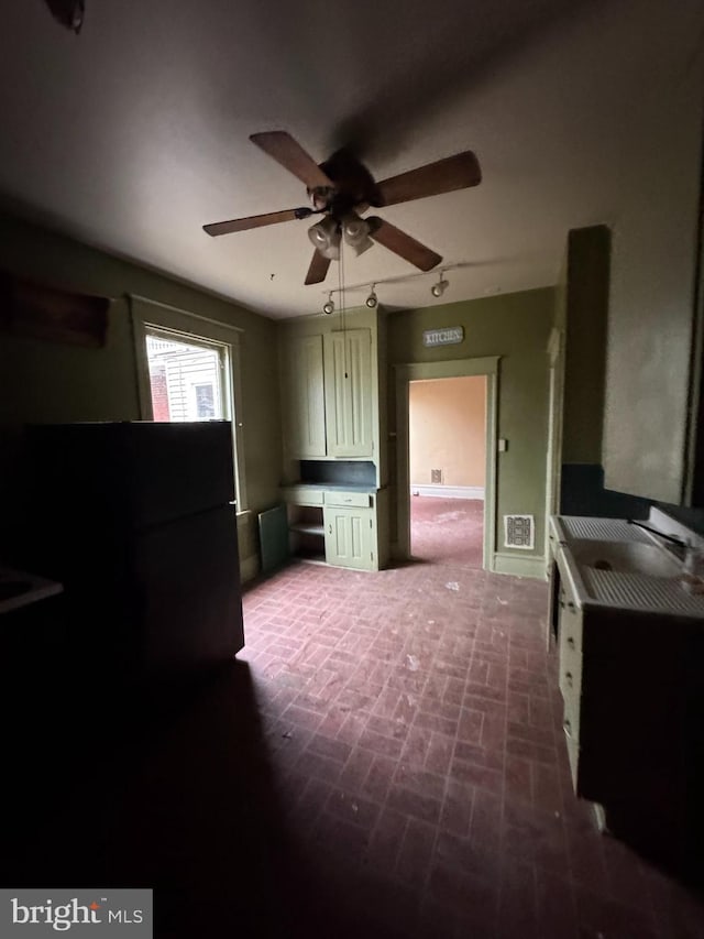 kitchen with brick floor, visible vents, and a ceiling fan