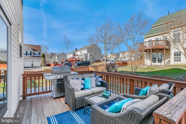 deck with french doors, a yard, outdoor lounge area, area for grilling, and a residential view