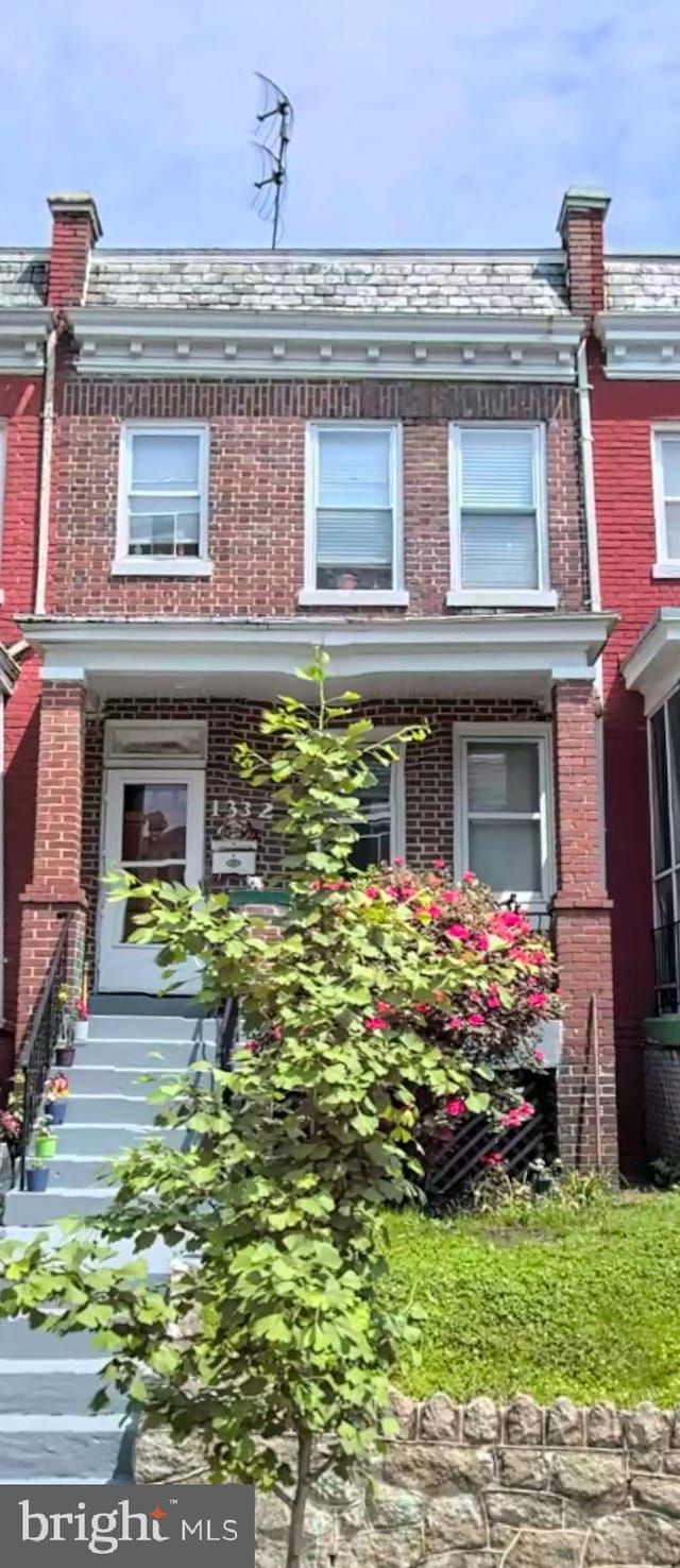 multi unit property featuring a high end roof and brick siding