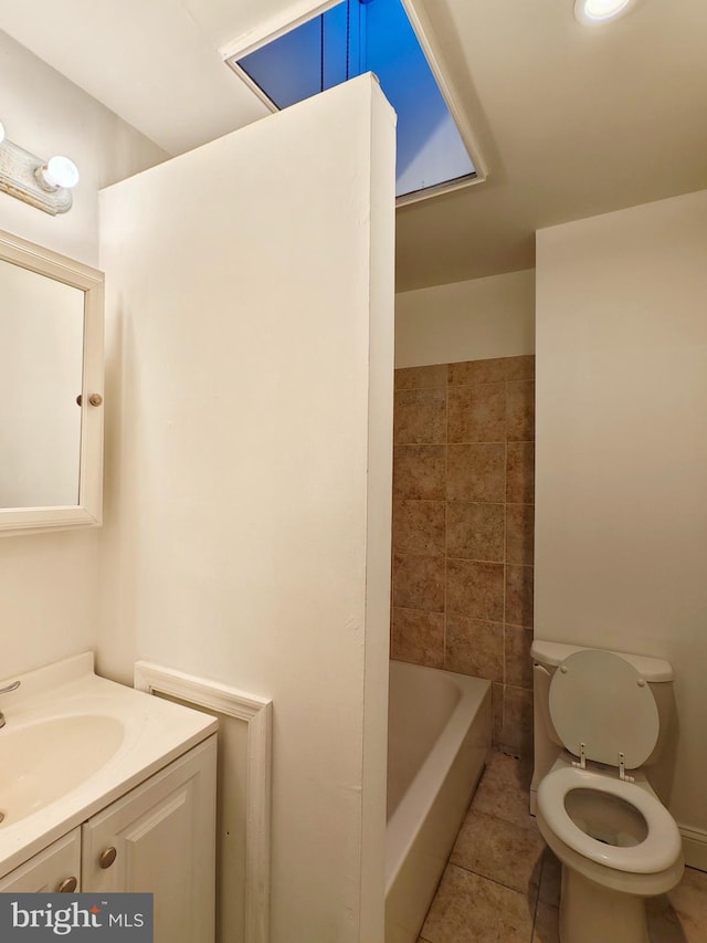 full bathroom featuring a washtub, vanity, toilet, and tile patterned floors