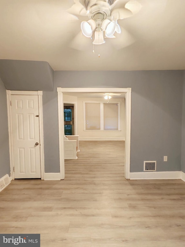 additional living space featuring light wood-type flooring, baseboards, visible vents, and ceiling fan