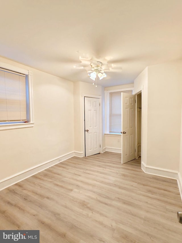 unfurnished bedroom with a ceiling fan, baseboards, and light wood finished floors