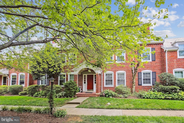 view of front facade featuring brick siding and a front lawn