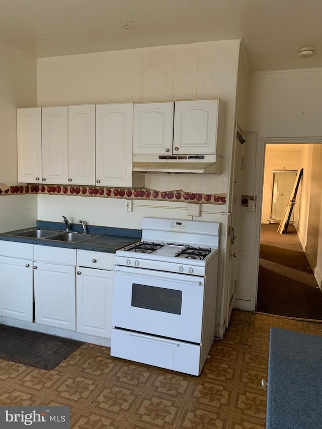 kitchen with white cabinetry, white gas range, under cabinet range hood, and a sink