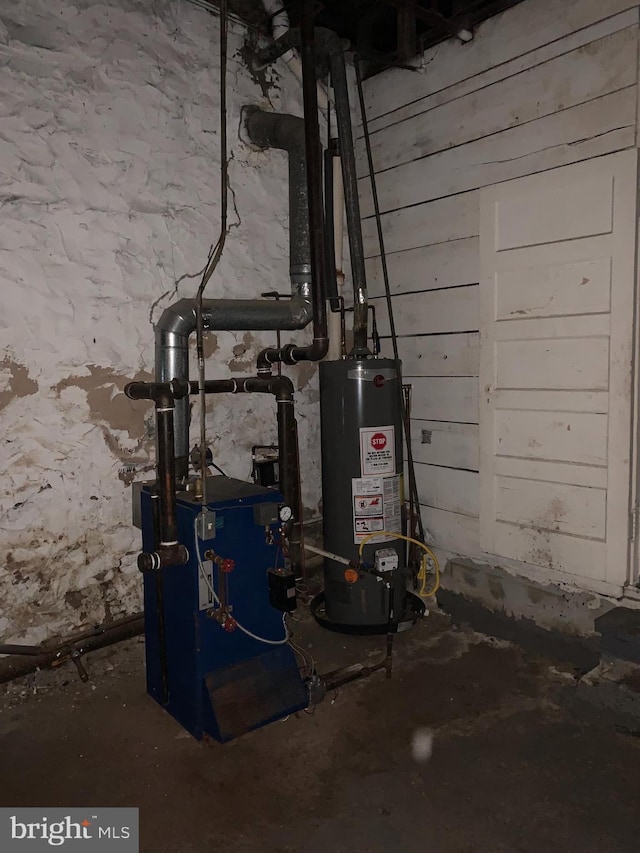 utility room with gas water heater and a heating unit