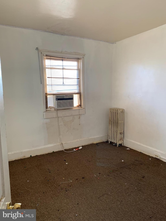 spare room featuring radiator, cooling unit, baseboards, and carpet floors