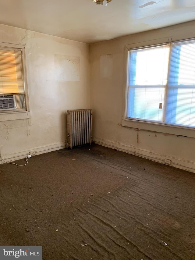 unfurnished room with cooling unit and radiator heating unit