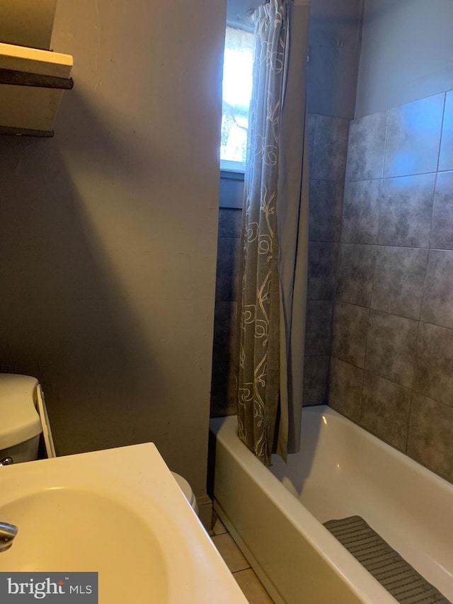 bathroom featuring toilet and shower / bath combo with shower curtain