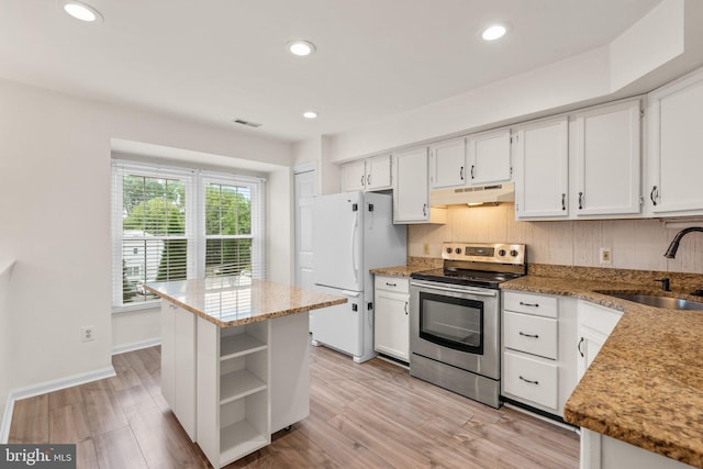 kitchen with under cabinet range hood, a sink, freestanding refrigerator, open shelves, and stainless steel range with electric stovetop