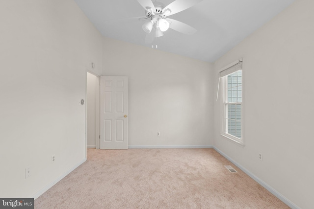 empty room featuring carpet floors, baseboards, visible vents, and vaulted ceiling