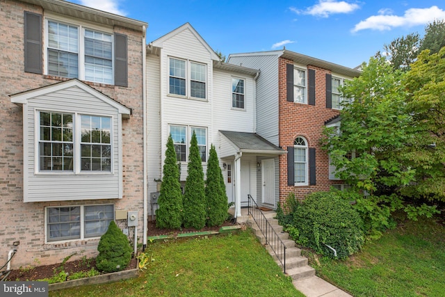 townhome / multi-family property featuring a front yard