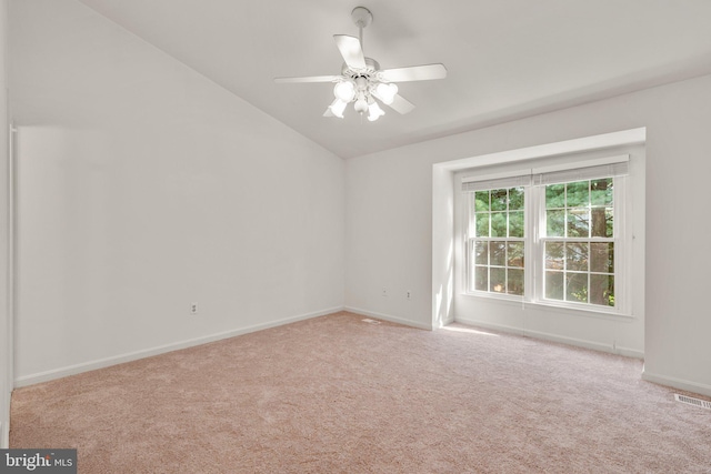 carpeted empty room with ceiling fan, baseboards, visible vents, and vaulted ceiling