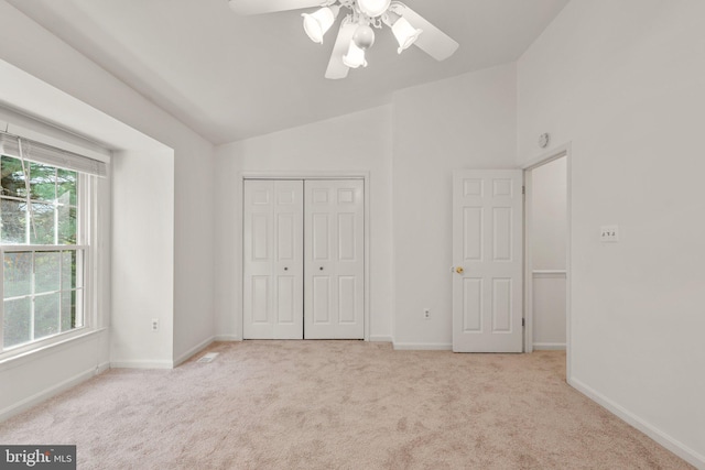 unfurnished bedroom with carpet floors, baseboards, vaulted ceiling, and a closet