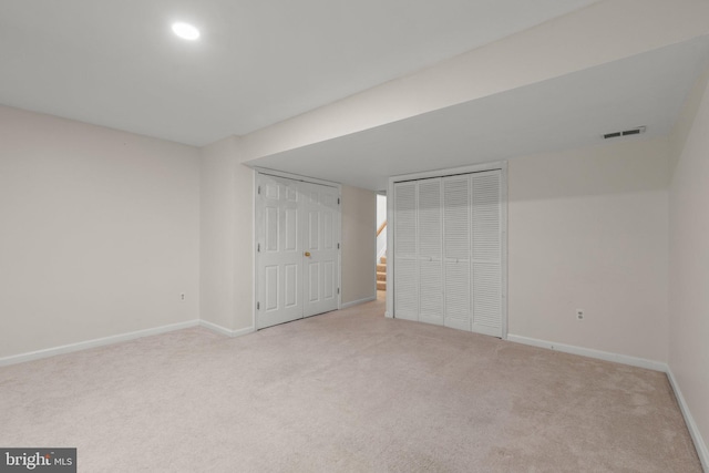 unfurnished bedroom with baseboards, carpet floors, visible vents, and multiple closets